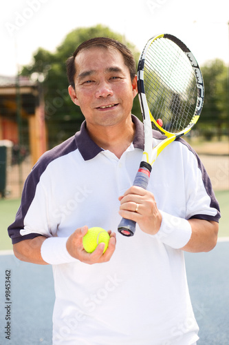 filipino tennis player holding a racket and ball © michael spring