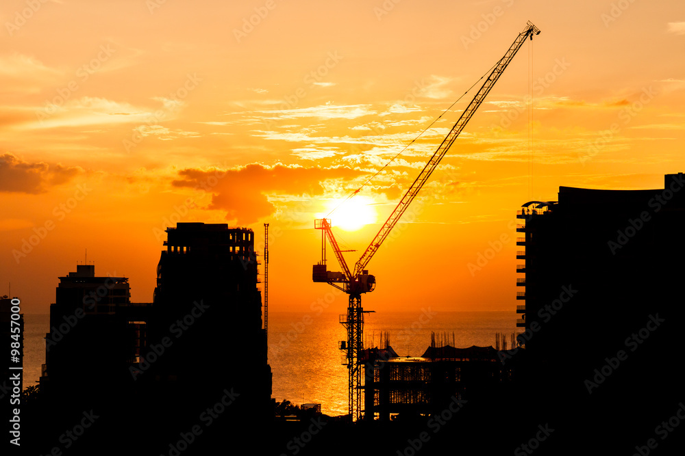silhouette of construction site crane with sunset on the sea silhouette of construction site crane with sunset on the sea