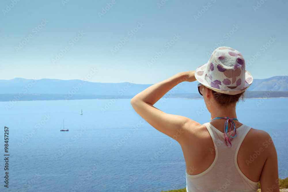 Young woman tourist watching the summer sea panorama Young woman tourist watching the summer sea panorama
