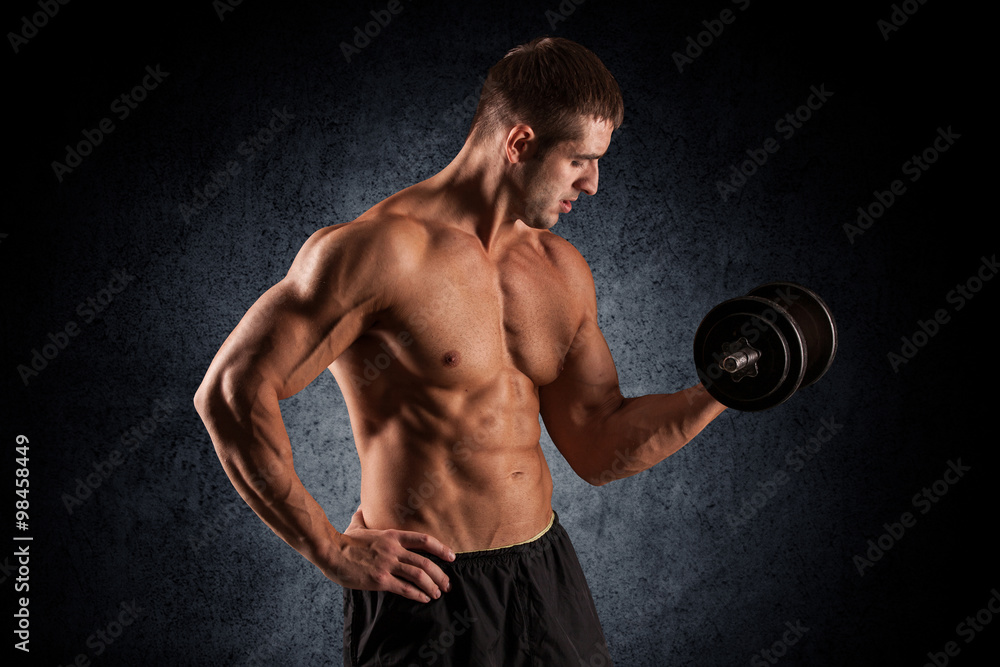 muscular young man lifting weights