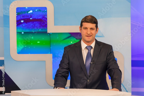 фотографія Male anchorman in tv studio. Live broadcasting