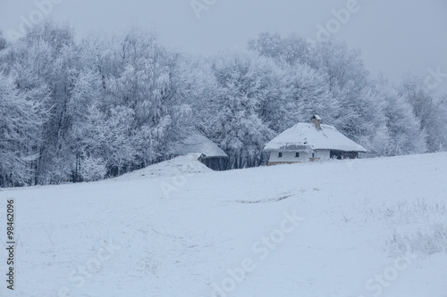 old wooden house in the middle of the forest in winter