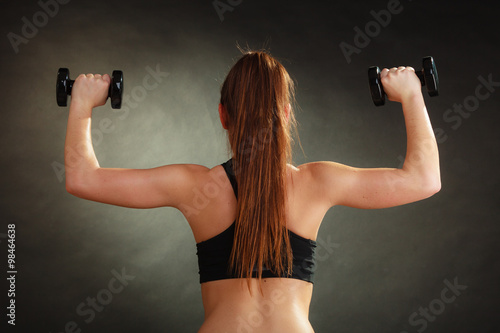 Fit woman exercising with dumbbells.