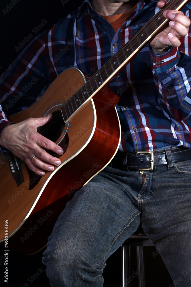 Obraz premium Musiker zieht Gitarre hoch, spielt