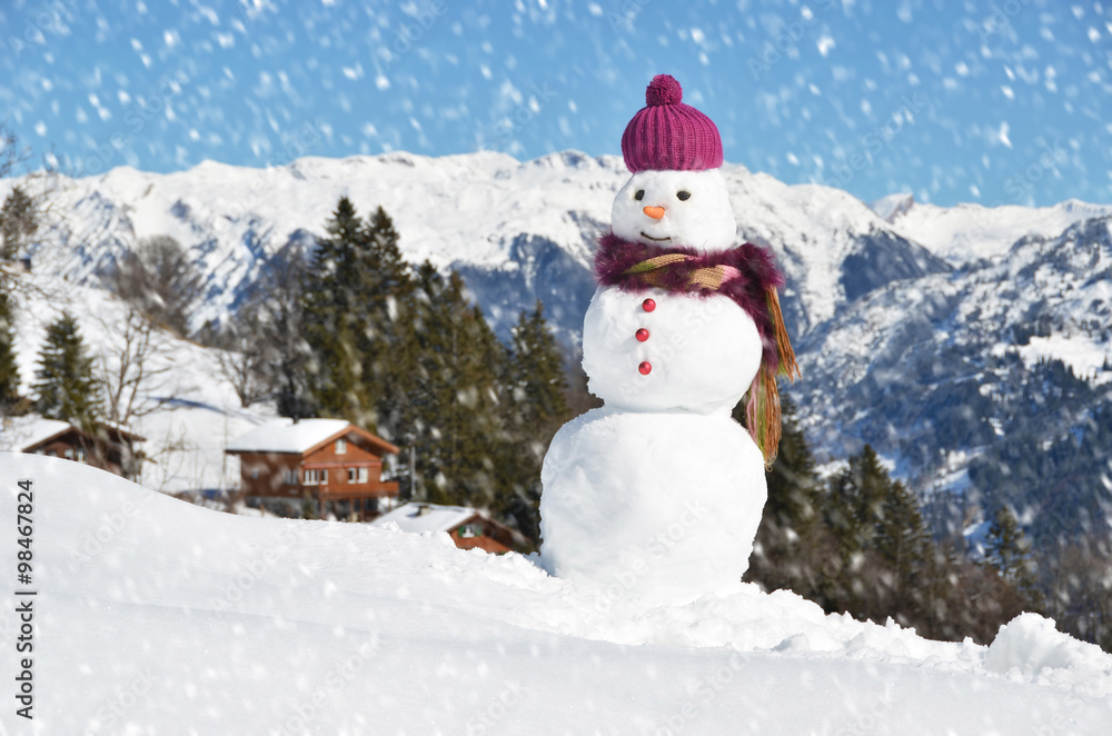 Fototapeta premium Snowman against Alpine panorama