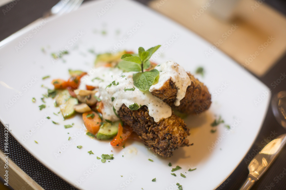 Grilled meat with sauce and herbs served at restaurant