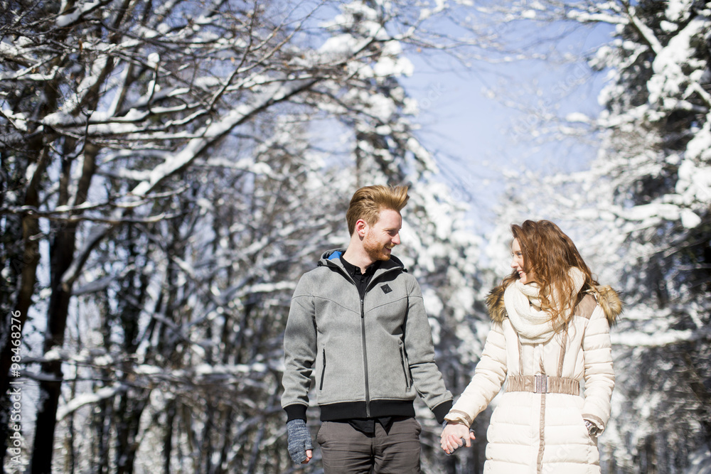 Young couple at winter forest Young couple at winter forest
