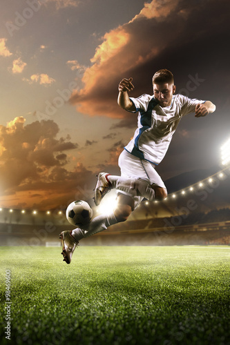 Soccer player in action on sunset stadium background © 103tnn