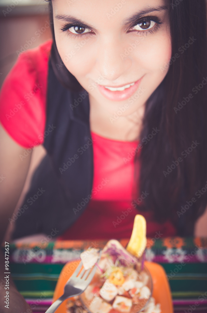 Beautiful young girl tasting a delicious fish ceviche, typical ecuadorian plate Beautiful young girl tasting a delicious fish ceviche, typical ecuadorian plate