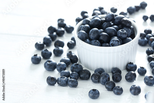 Blueberries in bowl on a white wooden background