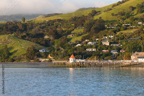 Small wooden pier with background of hill before sunset, Akaroa,