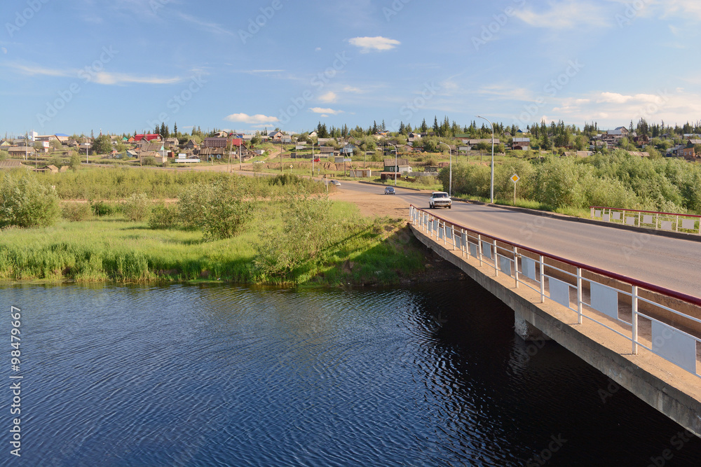 Fototapeta premium Rural area in the town of Mirny, Irelyakh bridge over the river.