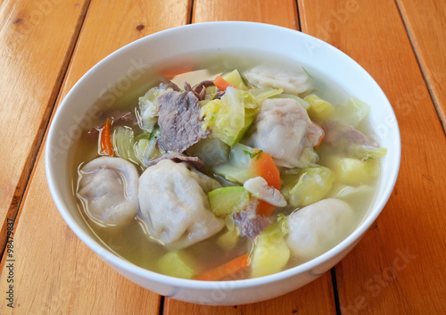 Soup with dumplings, vegetables and meat slices photo