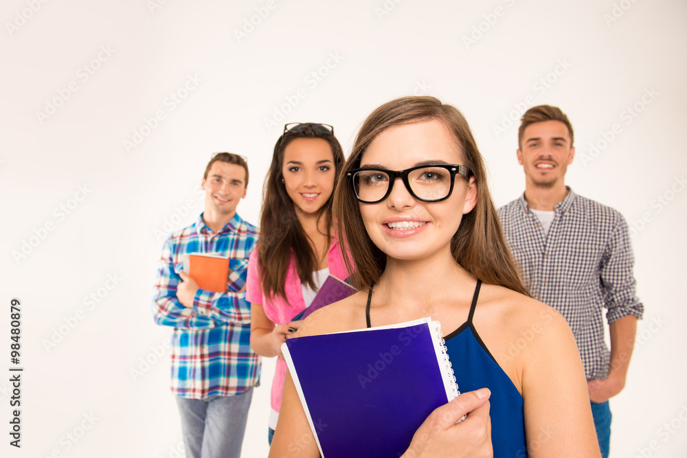 Confident group of students holding books and materials Confident group of students holding books and materials