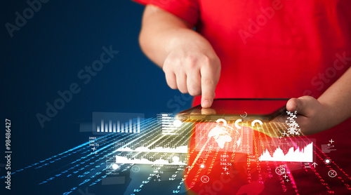 Hand holding touchpad tablet with business market graphs