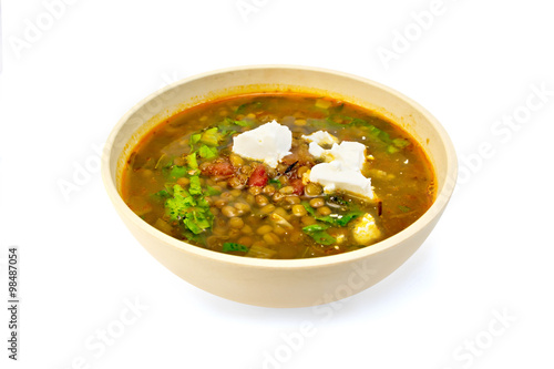 Soup lentil with spinach and cheese in yellow bowl