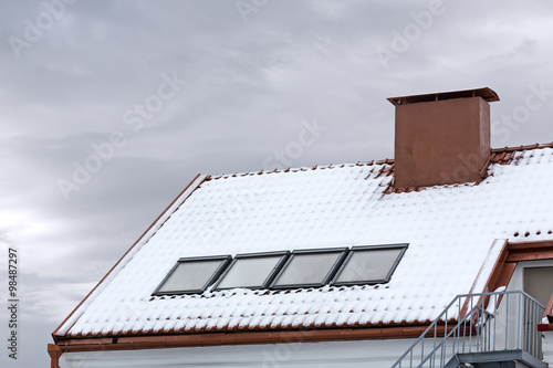 Foto skylight and red chimney on snow covered roof
