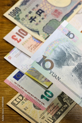 Banknoten großer Volkswirtschaften auf Holzhintergrund