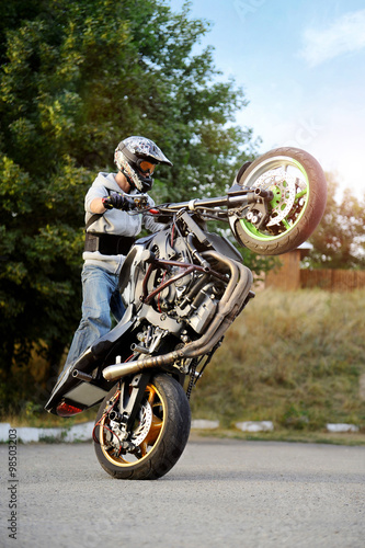 Pushing his limits. Stunt performer showing off his tricks on a motorbike soft smudged focus