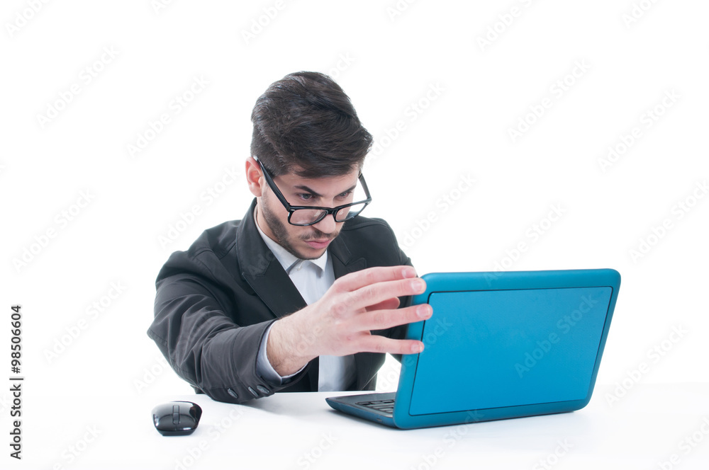 Young business man looking at his laptop with disappointment Young business man looking at his laptop with disappointment