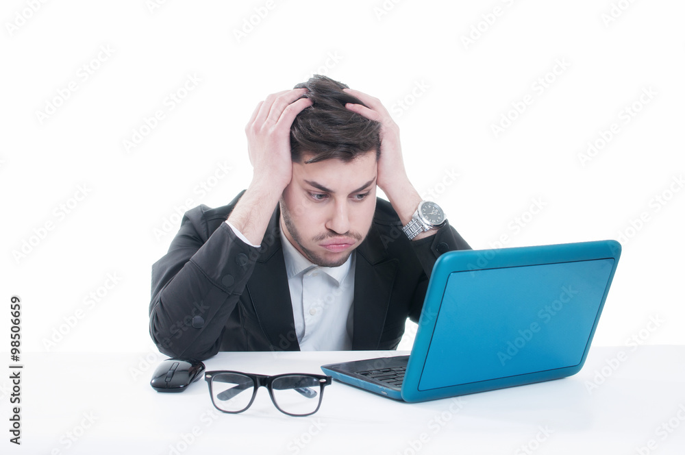 Young business man looking at his laptop with disappointment Young business man looking at his laptop with disappointment