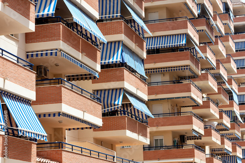 Facade of apartment building with balconies and awnings from the sun.