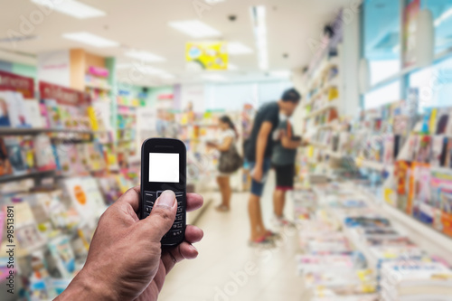 Phone white screen in hand on blurred book store