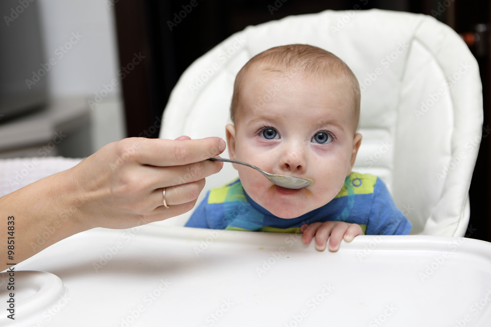 Baby boy has breakfast in highchair Baby boy has breakfast in highchair