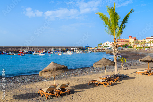 Palm tree and sunbeds on tropical beach in San Juan town on coast of Tenerife, Canary Islands, Spain © pkazmierczak