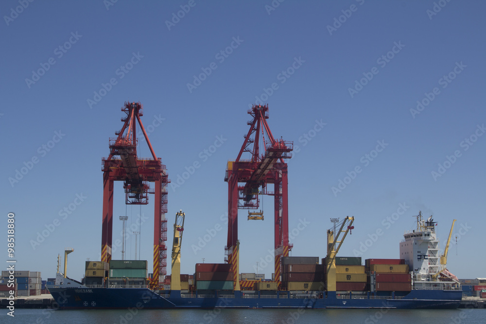 Ship in a port being unloaded the containers by a crane. Fremantle Ports, Fremantle Harbour, Cliff Street Fremantle WA 6160. Perth, Western Australia, Australia. Ship in a port being unloaded the containers by a crane. Fremantle Ports, Fremantle Harbour, Cliff Street Fremantle WA 6160. Perth, Western Australia, Australia.