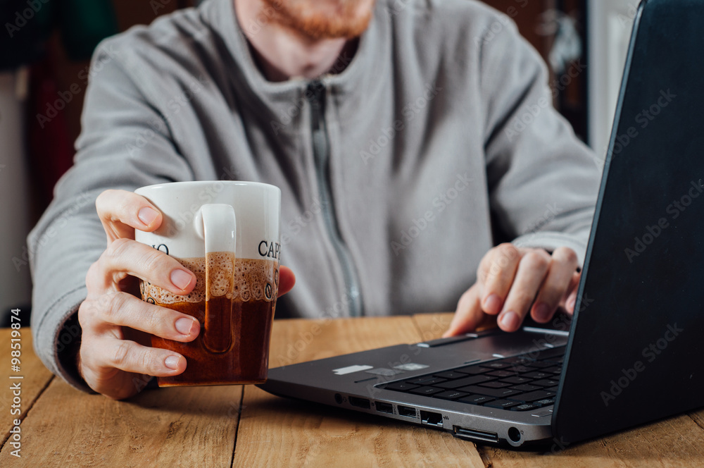 Young man working with laptop and coffee Young man working with laptop and coffee
