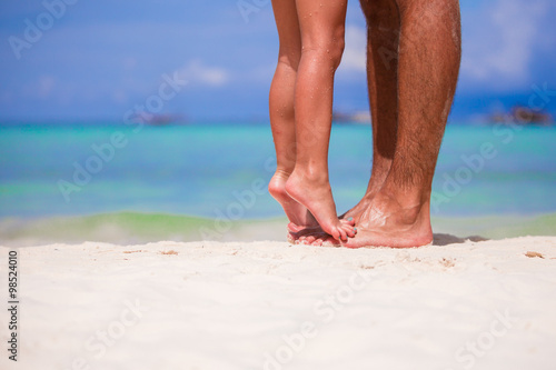 Closeup father and little daughter feet on a tropical beach
