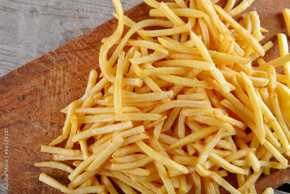 French fried potatoes on cutting board French fried potatoes on cutting board