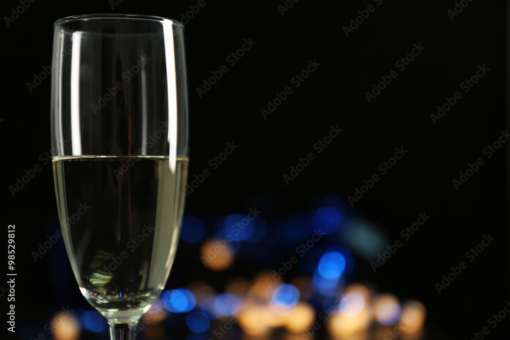 A glass of champagne with bokeh on dark background A glass of champagne with bokeh on dark background