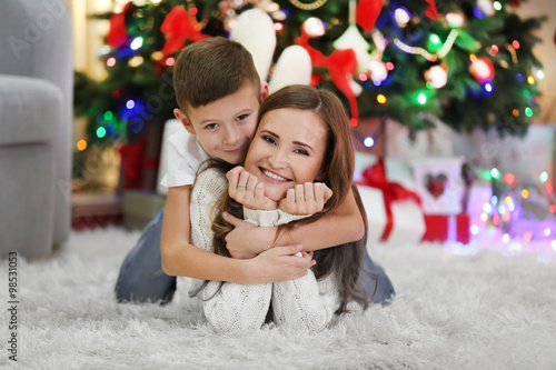 Mother with son near Christmas tree