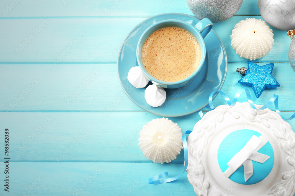 Tasty cupcake with bow, coffee cup and Christmas toys on color wooden background Tasty cupcake with bow, coffee cup and Christmas toys on color wooden background