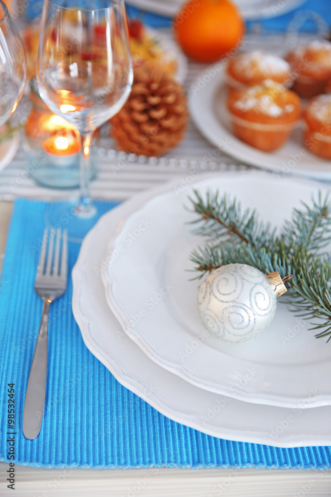 White plates with flatware on a Christmas table, close up White plates with flatware on a Christmas table, close up