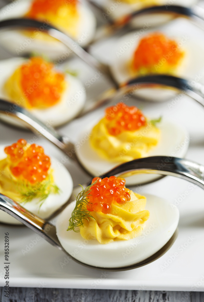 Deviled eggs with red caviar in a spoon Deviled eggs with red caviar in a spoon