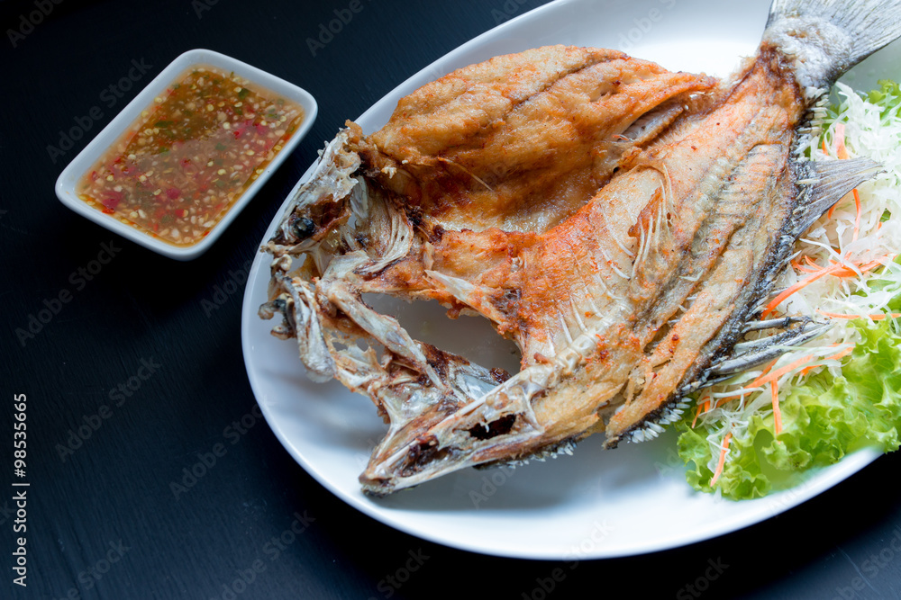 Fish dish - Deep fried Snapper fish eat with spicy sauce on blac