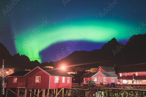 Beautiful picture of massive multicoloured vibrant Aurora Borealis, Aurora Polaris, also know as Northern Lights in the night sky over Norway, Lofoten Islands © tsuguliev