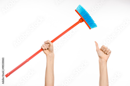 Fotografija Cleaning the house topic: human hand holding a red broom isolated on a white bac