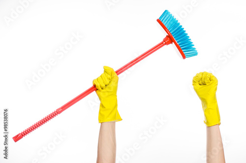 Cleaning the house topic: human hand in yellow rubber gloves holding a red broom isolated on a white background in studio © Parad St
