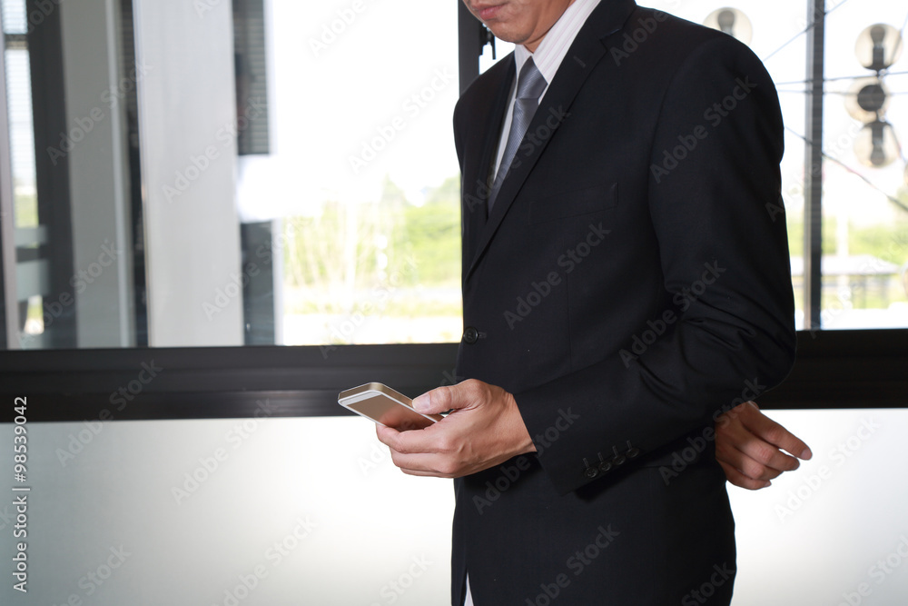Businessman stand up and look in smartphone device Businessman stand up and look in smartphone device