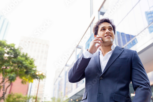 Portrait of confident businessman with mobile phone outdoors