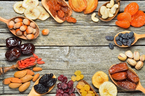 Mix of dried fruits and nuts on a wooden table - symbols of judaic holiday Tu Bishvat. Copyspace background.Top view.