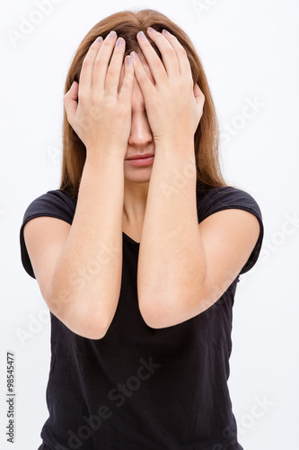 Stressed desperate young woman covered eyes by hands
