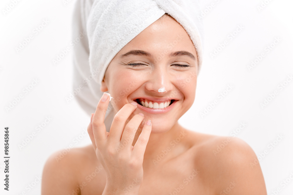 Cheerful attractive young woman with face cream on her nose Cheerful attractive young woman with face cream on her nose