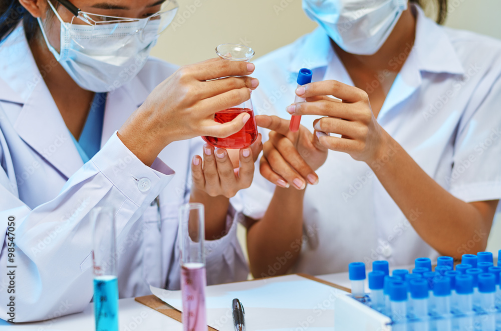 close up of scientists examining and comparing chemicals in laboratory
close up of scientists examining and comparing chemicals in laboratory