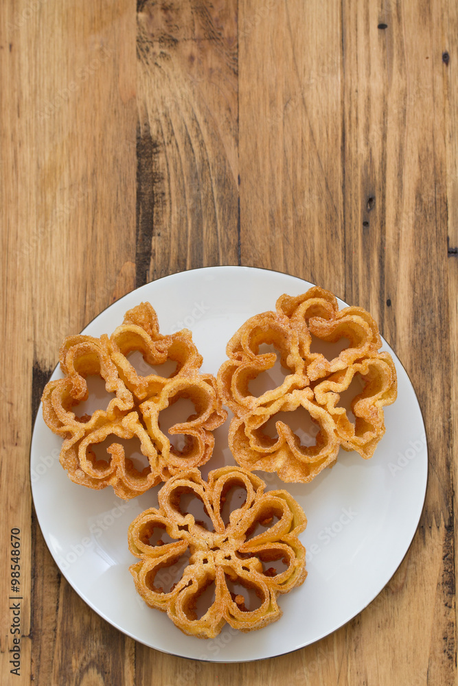 Fototapeta premium typical portuguese dessert filhos on white plate on brown background
