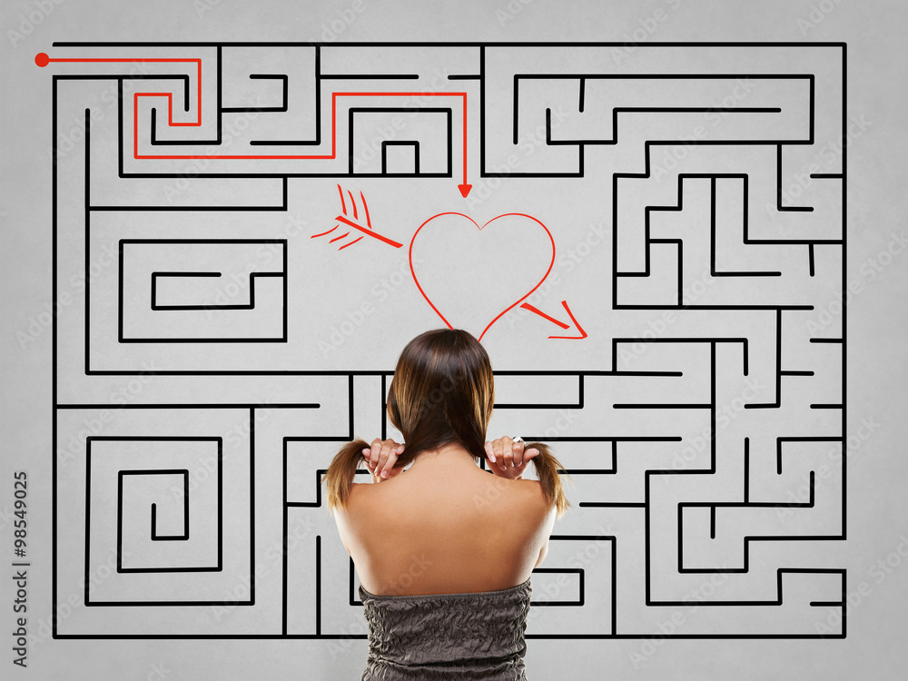 Woman pulling hair in front of labyrinth with love solution Woman pulling hair in front of labyrinth with love solution